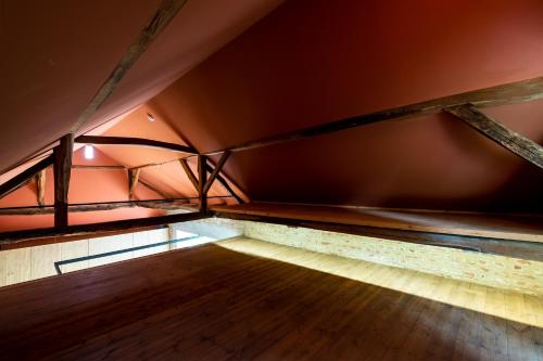 an empty room with a wooden floor in a attic at Almalomb Apartman in Hosszúhétény