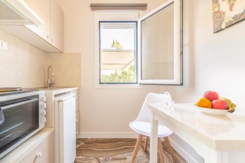 a kitchen with a table and a bowl of fruit at Stylish Apartment near the Beach with parking in Gázion