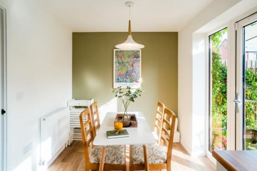 a dining room with a white table and chairs at Artist's Garden on Wolsey Island in Leicester