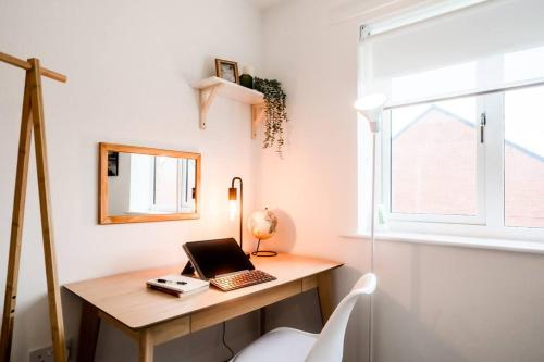 a room with a desk with a laptop on it at Artist's Garden on Wolsey Island in Leicester