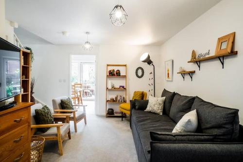 a living room with a couch and a tv at Artist's Garden on Wolsey Island in Leicester