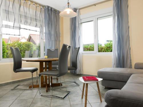 ein Wohnzimmer mit einem Tisch, Stühlen und einem Sofa in der Unterkunft Haus Kaltenhof in Insel Poel