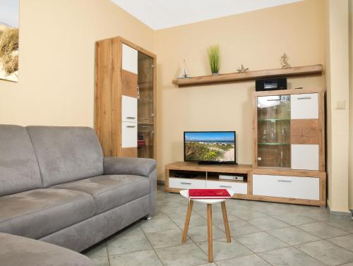 ein Wohnzimmer mit einem Sofa und einem TV in der Unterkunft Haus Kaltenhof in Insel Poel