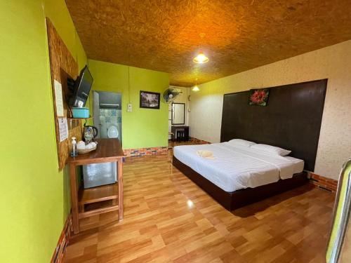 a bedroom with a bed in a room with green walls at Prabpluem Resort in Chiang Klang