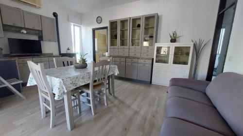 cocina y sala de estar con mesa y sofá en La maison d'Eden en Ginosa Marina