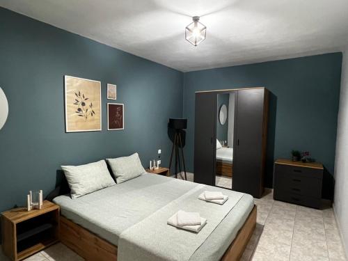 a bedroom with a large bed with blue walls at Cozy house in Xanthi