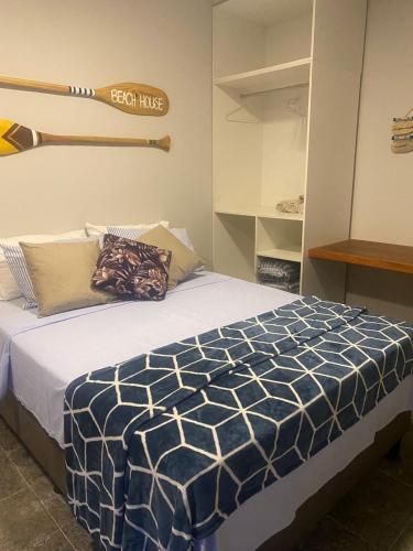 a bedroom with a bed with a baseball bat on the wall at Segunda Casa- Seu cantinho na Praia do Morro em Guarapari - Quartos suítes 2 até 4 pessoas in Guarapari