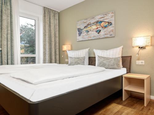 ein großes Bett in einem Zimmer mit Fenster in der Unterkunft Haus Südwester Austernperle in Timmendorf