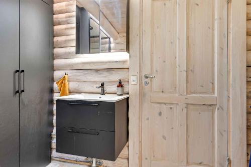 un bagno con lavandino accanto a una porta in legno di Dmningen 1, 4400 Kalundborg a Kalundborg