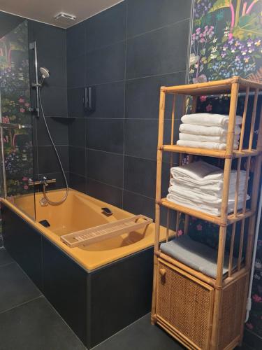 a bathroom with a tub and a rack of towels at Les Colibris - Standing et Jardin - 3 étoiles in Cluses