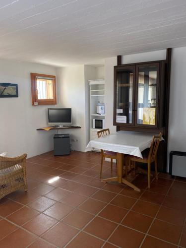 ein Wohnzimmer mit einem Tisch und einem TV in der Unterkunft Casa Vignole-Badasci in Orselina
