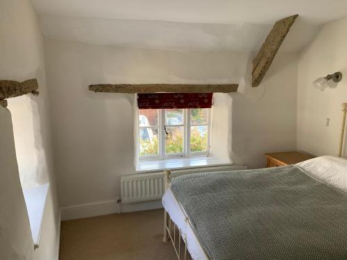 a bedroom with a bed and a window at Brewers Cottage in Kings Nympton