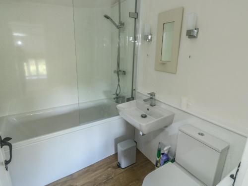 a white bathroom with a sink and a toilet at Brewers Cottage in Kings Nympton