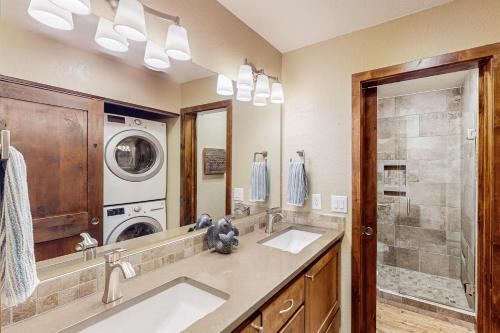 a bathroom with two sinks and a washer and dryer at Lake Chelan Shores: Sandy Beach Delight #1-5 in Chelan