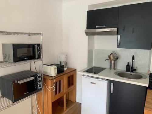 a small kitchen with a sink and a microwave at St ouen centre 20mn de châtelet Ligne 14 in Saint-Ouen