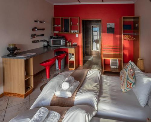 a living room with a couch and a kitchen at Island Cottage Guesthouse in Lüderitz