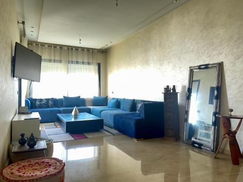 ein Wohnzimmer mit einem blauen Sofa und einem TV in der Unterkunft Stunning apartment with pools in Tamaris