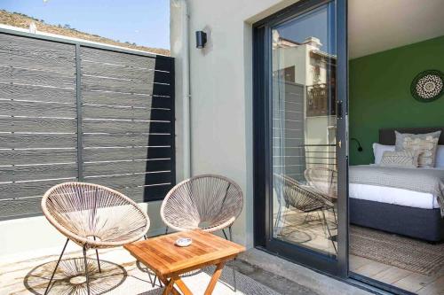 een balkon met 2 stoelen, een bed en een tafel bij The Palm Flats - Palm Paradise in Kaapstad