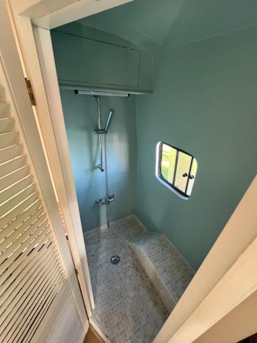 Avesnelles的住宿－Sympathique camping car J9，一个小浴室,设有窗户和楼梯