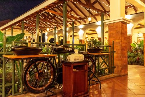 a bike parked in a building with two tables and ailion at Midland Hotel Nakuru in Nakuru