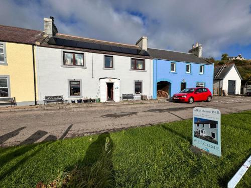 a red car parked in front of a house at Sea Song, Selkie House in Helmsdale