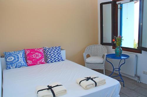 KallirákhiにあるLadanos Apartment Thassosのベッドルーム1室(ベッド1台、椅子、窓付)