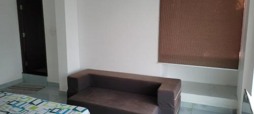 a brown bench in the corner of a room at Yogis Inn in Kozhikode