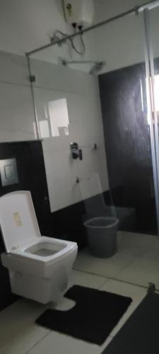 a bathroom with a white toilet and a sink at Yogis Inn in Kozhikode
