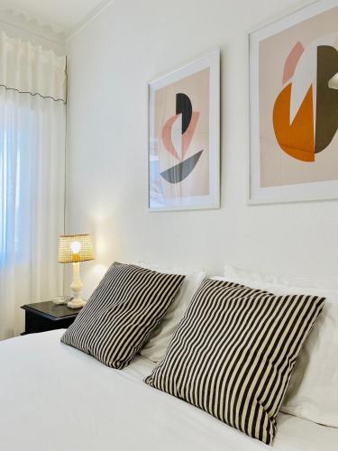 1 dormitorio con 1 cama blanca y 2 cuadros en la pared en Bright modern 3 BR in Portimao downtown, en Portimão