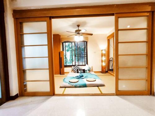 a bedroom with sliding glass doors with a bed in it at 古城豪华泳池别墅/可步行夜市塔佩门/轰趴/烧烤/团体出游首选 Yellow House Garden Villa in Chiang Mai
