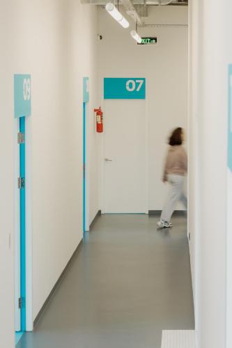 a person walking down a hallway in a building at 11+1 by TUMO in Dilijan