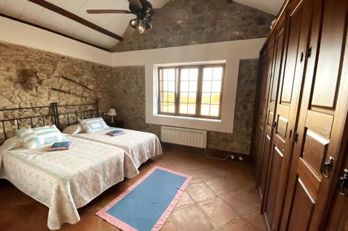 een slaapkamer met 2 bedden en een raam bij Casa Rural de Ensueño en Parque Natural de Despeñaperros in Santa Elena