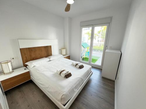 a bedroom with a bed with two towels on it at PUSHE Playa Granada Beach & Golf 21 in Motril