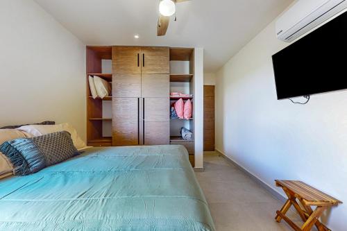 a bedroom with a bed and a flat screen tv at Rainbow Fish Hideaway @ TAO Santamar E201 in Akumal