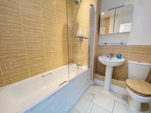 a bathroom with a toilet and a sink and a tub at Olympic Village Home - Victory in Portland