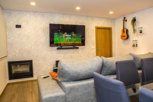 Il comprend un salon doté d'un canapé et d'une télévision à écran plat. dans l'établissement Toural House, à Arcos de Valdevez