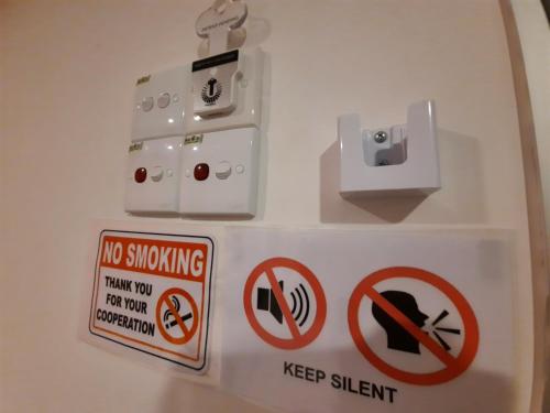 Una señal que dice que no se puede fumar y guardar silencio. en Good2Stay Hostel en Melaka
