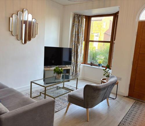 a living room with a couch and a table and a tv at Sheffield 3-bedroom house with free street parking in Sheffield
