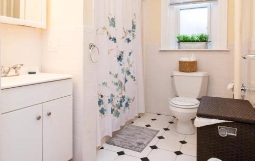 a white bathroom with a toilet and a sink at Luxury 5BR Apartment in NYC! in New York
