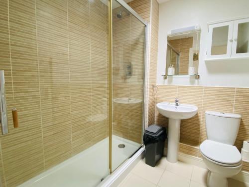 uma casa de banho com um chuveiro, um WC e um lavatório. em Olympic Village Vela - Portland em Portland