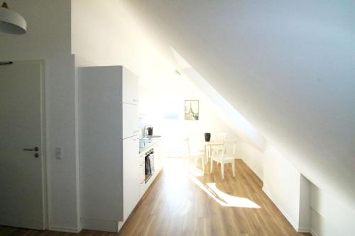 een witte kamer met een tafel en een wit plafond bij Work & Stay Apartment Ingolstadt in Ingolstadt