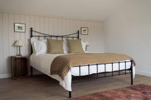a bedroom with a large bed with white sheets and pillows at The Walled Garden in Totnes