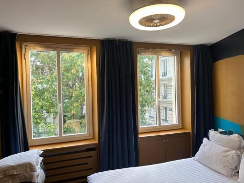 パリにあるアパルトマン ソンシエ ドーベントンのベッドルーム1室(窓2つ、ベッド1台付)