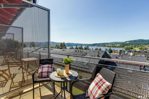 a balcony with a table and chairs and a view at KORZO LIPNO 2 in Lipno nad Vltavou