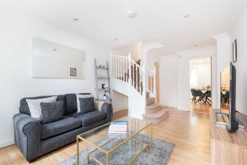 a living room with a couch and a table at Old Street - 4BR Townhouse with Patio - CityApartmentStay in London