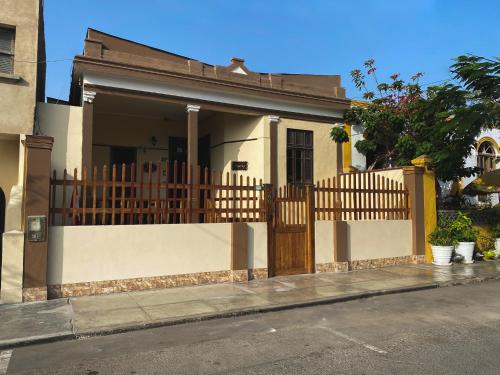 a house with a wooden gate and a fence at Villa La Punta in Lima