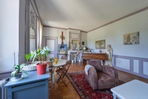 uma sala de estar com uma mesa e uma cadeira em Petit Gîte de Villecomte em Sainte-Solange