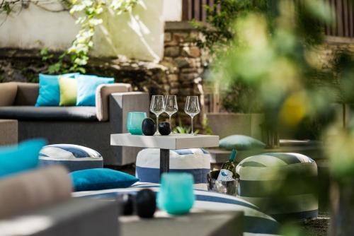 una mesa con copas de vino y un sofá en Hotel am Ochsentor, en Andernach