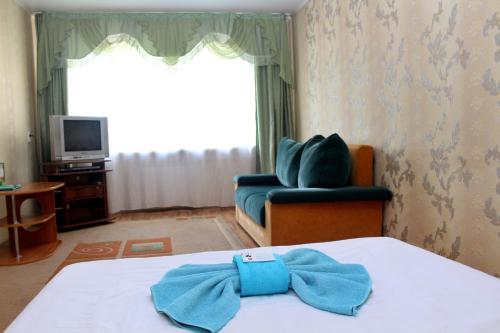 Una habitación con una cama con una pajarita azul. en Валенсия, en Petropavlovsk