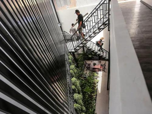 a group of people walking down a staircase with plants at Hotel De Palace in Phnom Penh